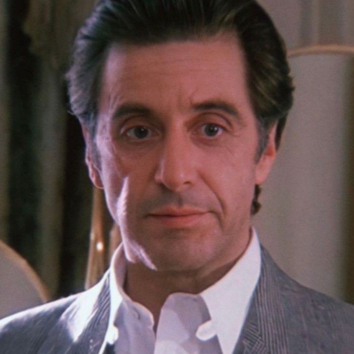 a man in a gray suit and white shirt looking at the camera with an