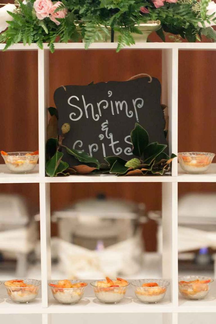 a sign that says shrimp and chips is on a shelf with bowls in front of it