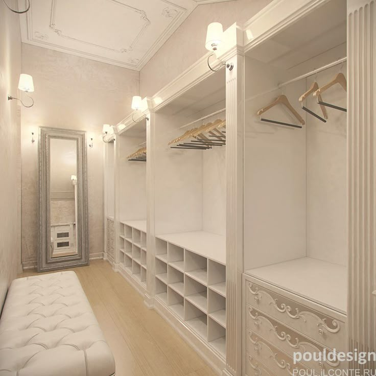 a walk in closet with white walls and shelving units on both sides, along with a bench