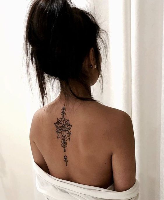 Back tattoos of a woman; Ribbon tattoos; Flower tattoos; Cross tattoos; Little p...