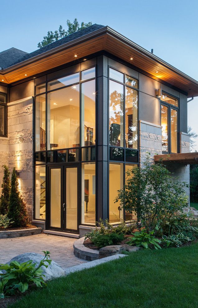 a modern house with glass walls and lots of windows