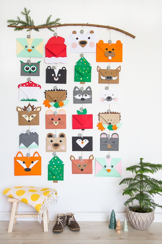 an animal themed wall hanging on a white wall next to a green plant and potted tree