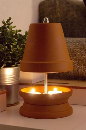 a lamp that is sitting on a table next to a potted plant and some books