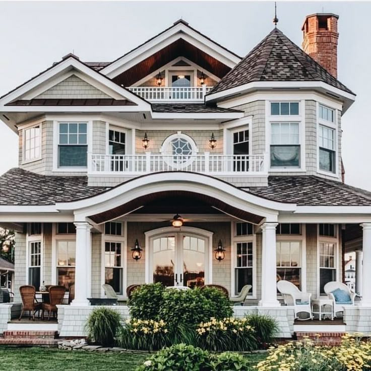 a large white house with lots of windows on it's front porch and balcony