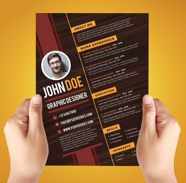 a person holding up a black and yellow resume with an orange stripe on the bottom