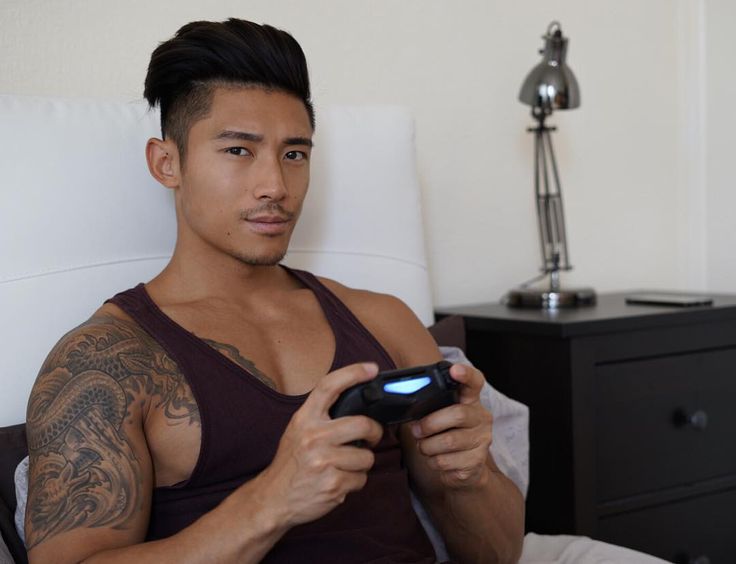 a man sitting in bed holding a game controller