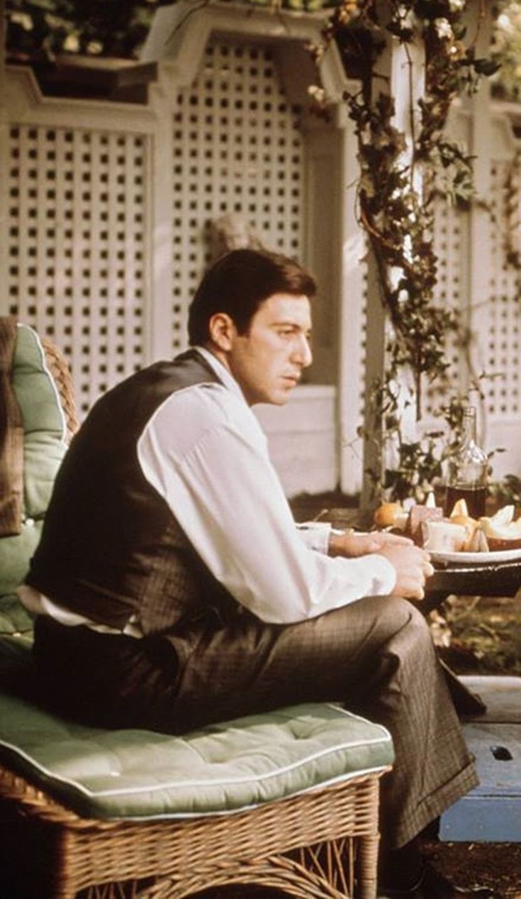 a man sitting on top of a chair next to a table
