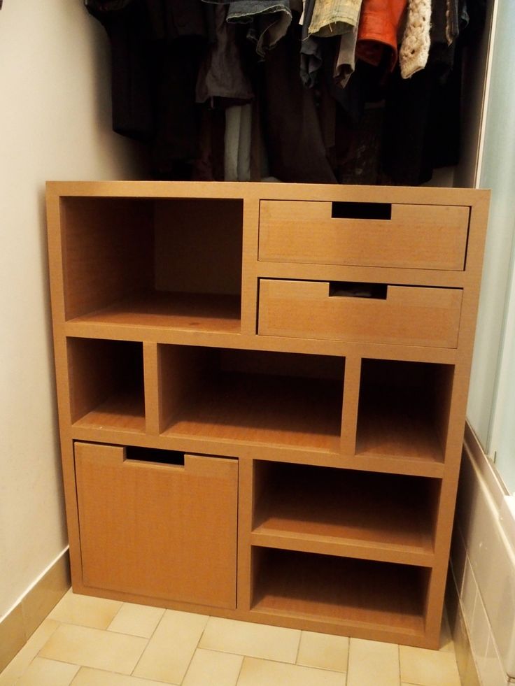 a closet with clothes hanging on the rack and shoes in it's storage compartment