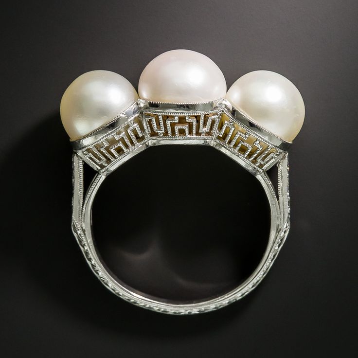 A trio of lustrous pearls--a natural freshwater in the center (imbued with a tou...