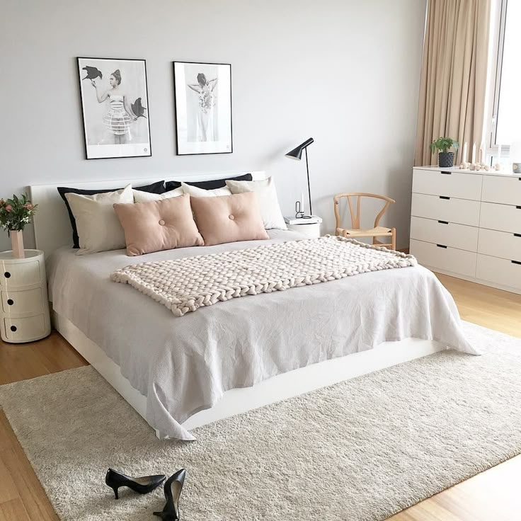 a bedroom with a bed, dresser and two pictures on the wall above it's headboard