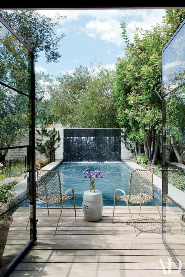french doors lead to rectangular pool with sight line to beautiful wall fountain