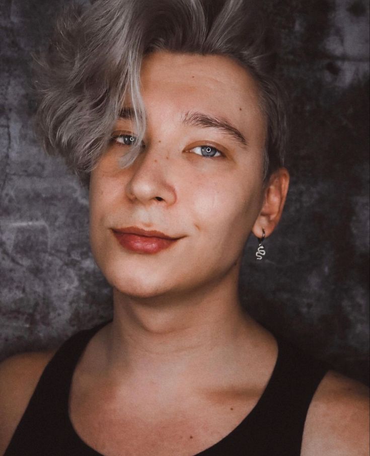 A Woman With Grey Hair And Blue Eyes Looks At The Camera While Wearing a-woman-with-grey-hair-and-blue-eyes-looks-at-the-camera-while-wearing