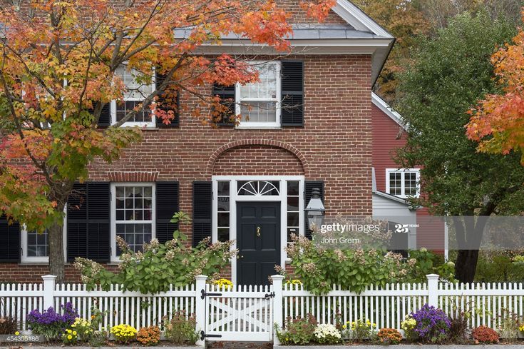 Charming New England brick house with picket fence. | White picket