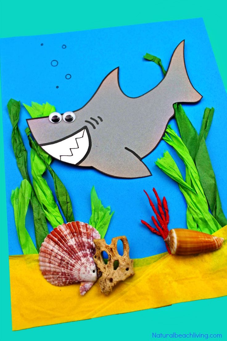 an ocean scene made out of paper and seaweed with a shark in the background