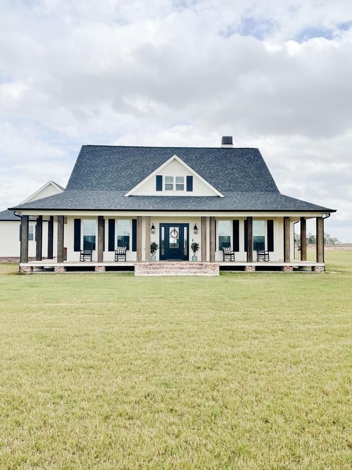 a large white house sitting on top of a lush green field