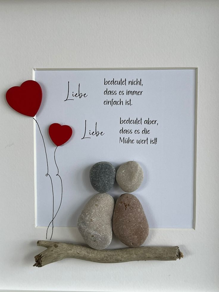 two rocks and a heart shaped balloon in a white frame with a poem