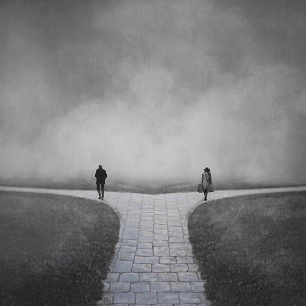 This may contain: two people walking down a path in the middle of a field with clouds above them