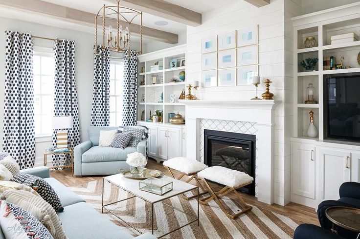 Chic White Living Room Features A Ottoman Fitted With Recessed Tray Doubling As Coffee Table Facing Two Gray Folding Stools Placed In Front Of