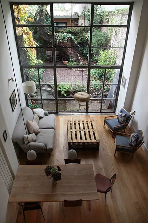 an overhead view of a living room with wood flooring and large windows that look out onto the backyard