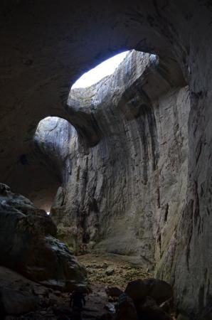 This may contain: the light is shining through an opening in a cave