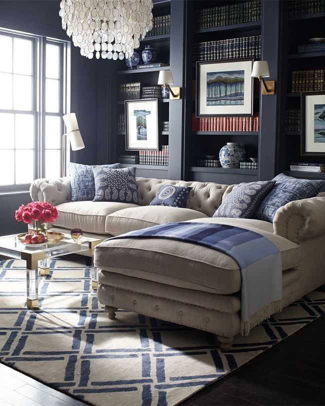 I can't get my eyes off this gorgeous library! The contrast between the tufted beige linen sofa and the dark navy built-in bookshelves are simply marvelous, drawing your eye to the lovely details of the beautiful sofa. I really like how the stylish acrylic and brass coffee table and the fabulous geometric rug are visua