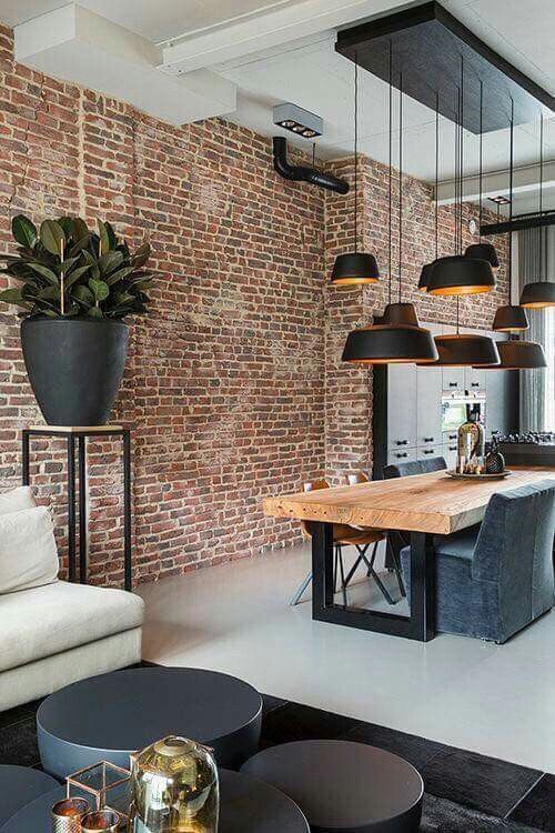 a living room filled with furniture next to a brick wall and floor covered in lots of windows