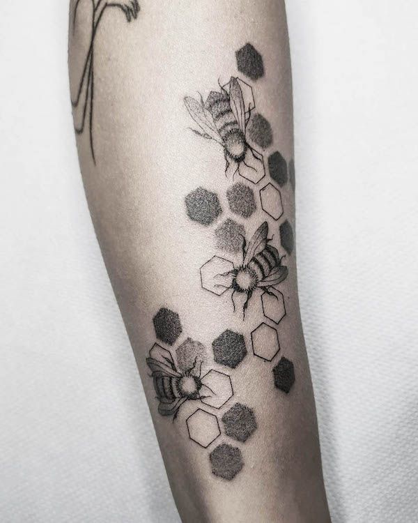A Black And White Photo Of Honeycombs With Bees On Its Arm