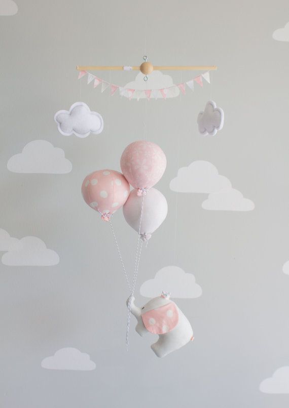 a baby crib with pink and white balloons floating in the sky above it is a cloud wall decal