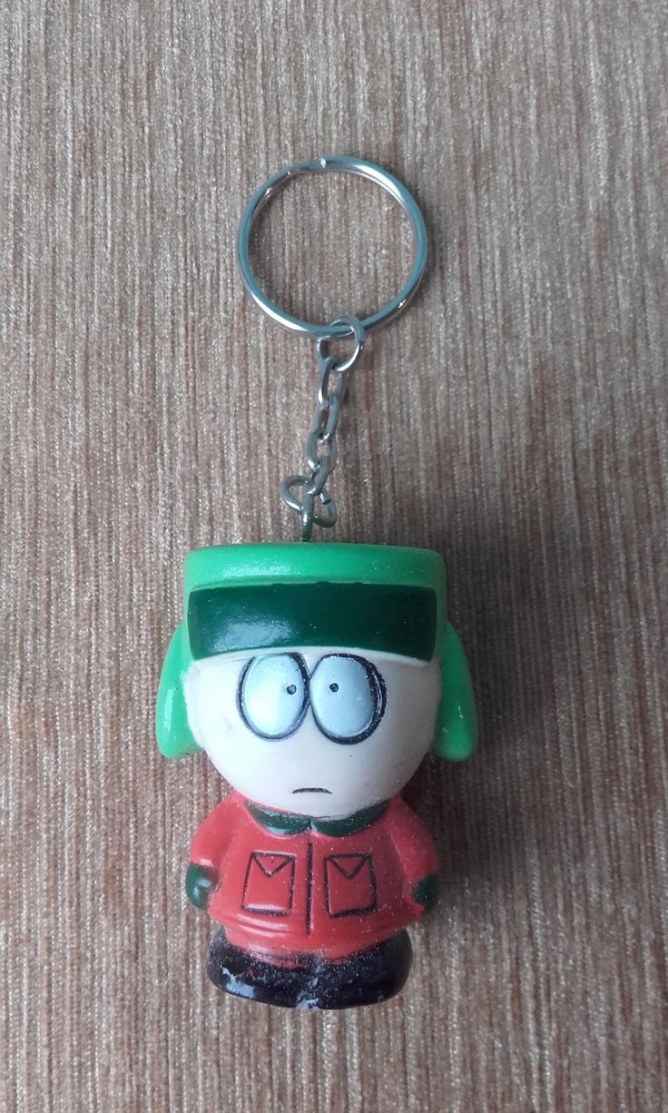 A Keychain With A Cartoon Character Wearing A Green Hat And Glasses On It a-keychain-with-a-cartoon-character-wearing-a-green-hat-and-glasses-on-it