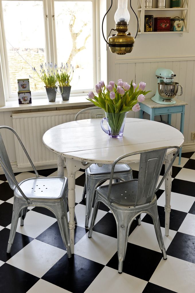 a white table and chairs in a room with black and white checkered flooring