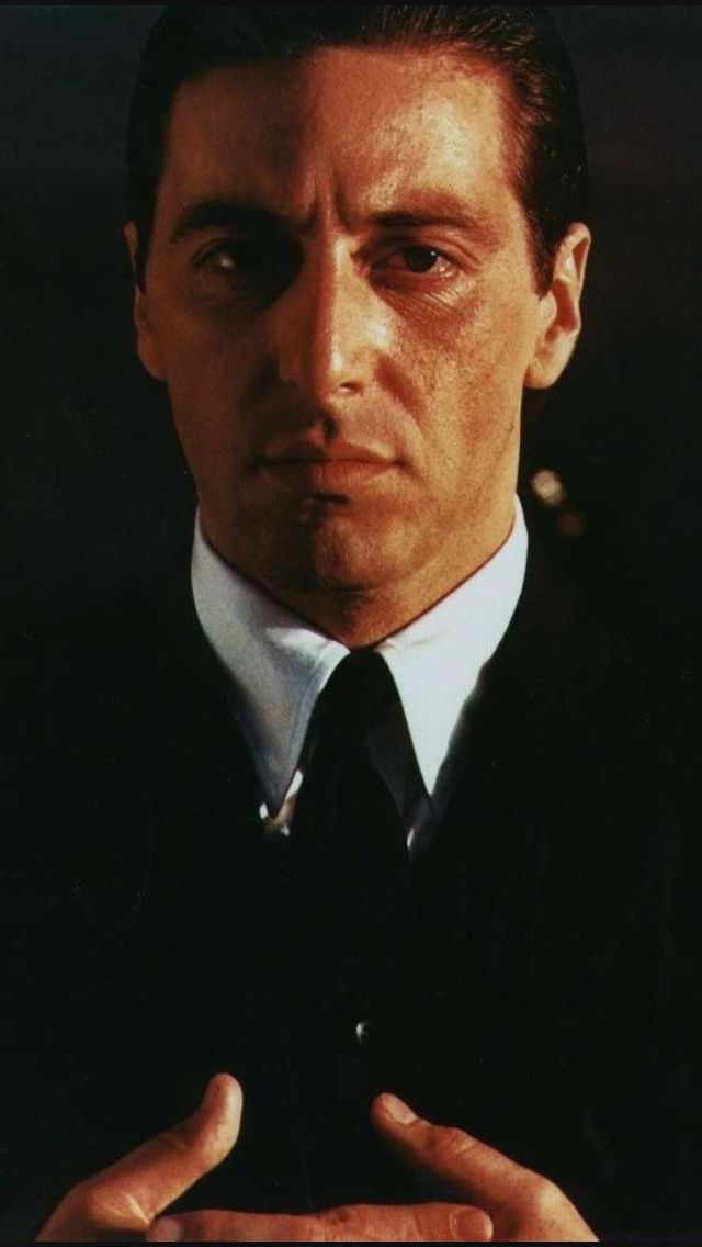 a man in a suit and tie holding his hands together