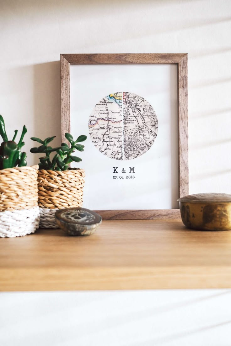 a wooden frame sitting on top of a shelf next to potted plants