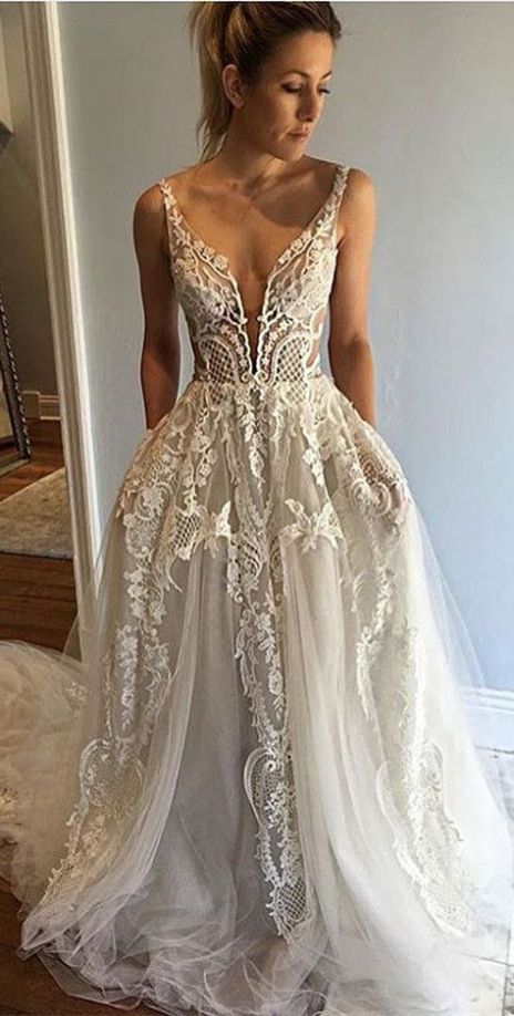 a woman in a wedding dress standing on the stairs with her back to the camera