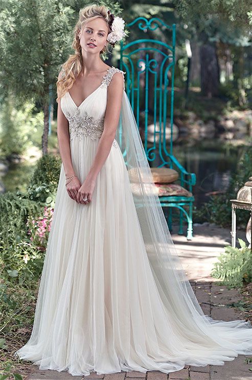 a woman in a wedding dress standing on a brick path with her hand on her hip