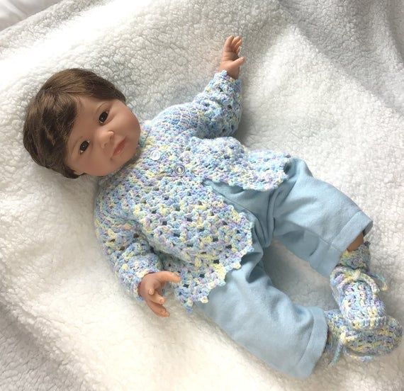 Size 0 to 3 months. This is a little crocheted baby coat and booties set, in a p...