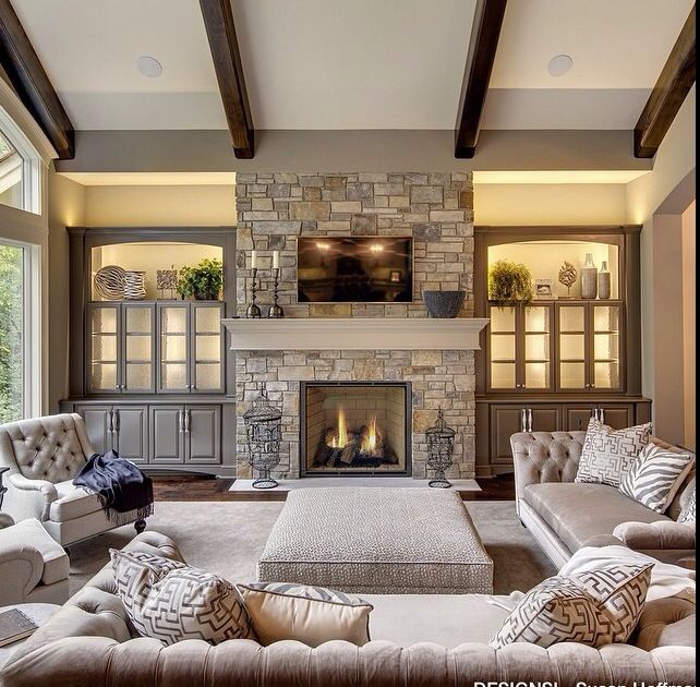 a living room filled with furniture and a fire place in the middle of a room