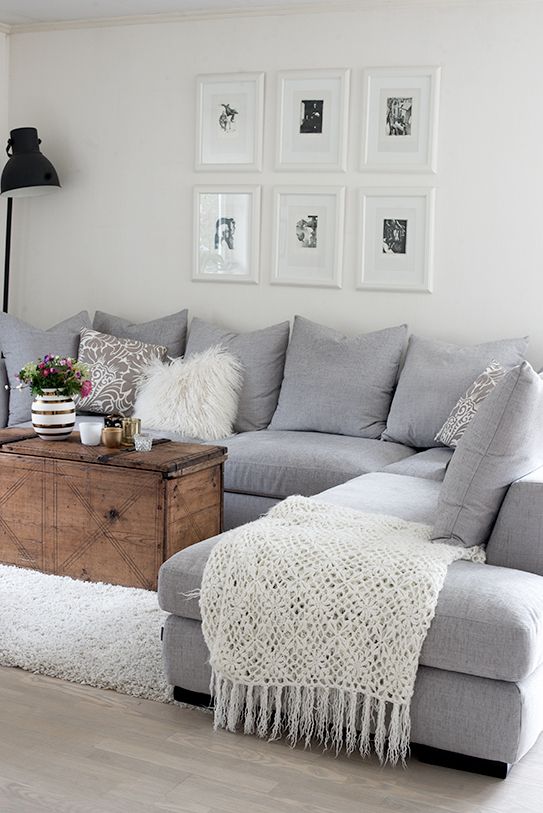 a living room with gray couches and white rugs on the floor next to a coffee table