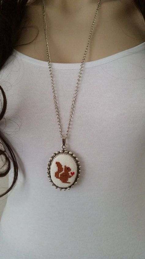 This cross stitch necklace is made of cotton thread,linen fabric,silver plated c...