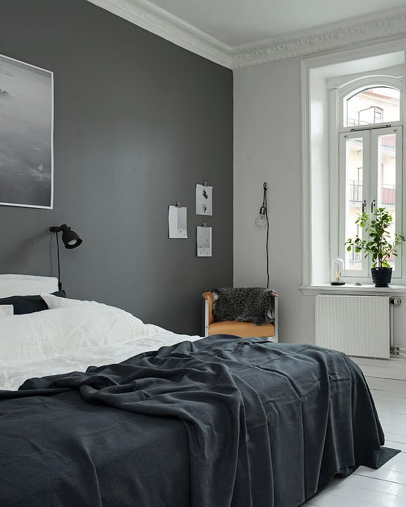 a bed room with a neatly made bed next to a window and a painting on the wall