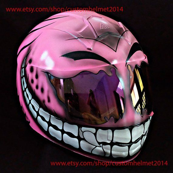 a pink motorcycle helmet with white teeth on it