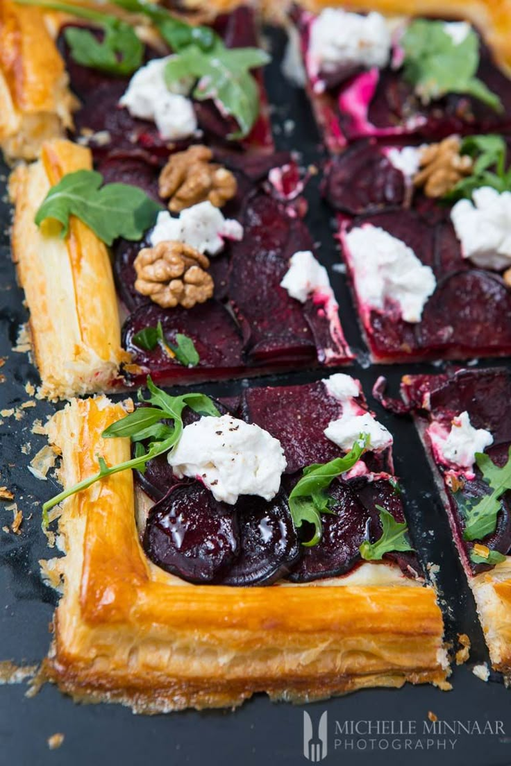 a close up of a pie with cherries and goat cheese on the top crust