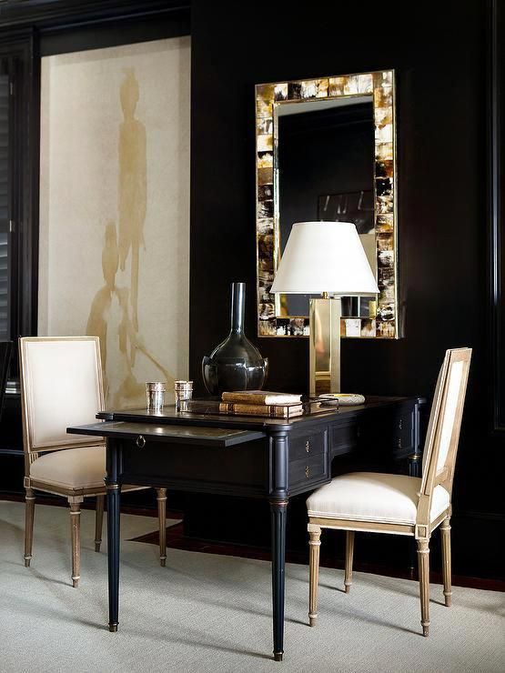 Black and gold home office features walls painted bold black lined with