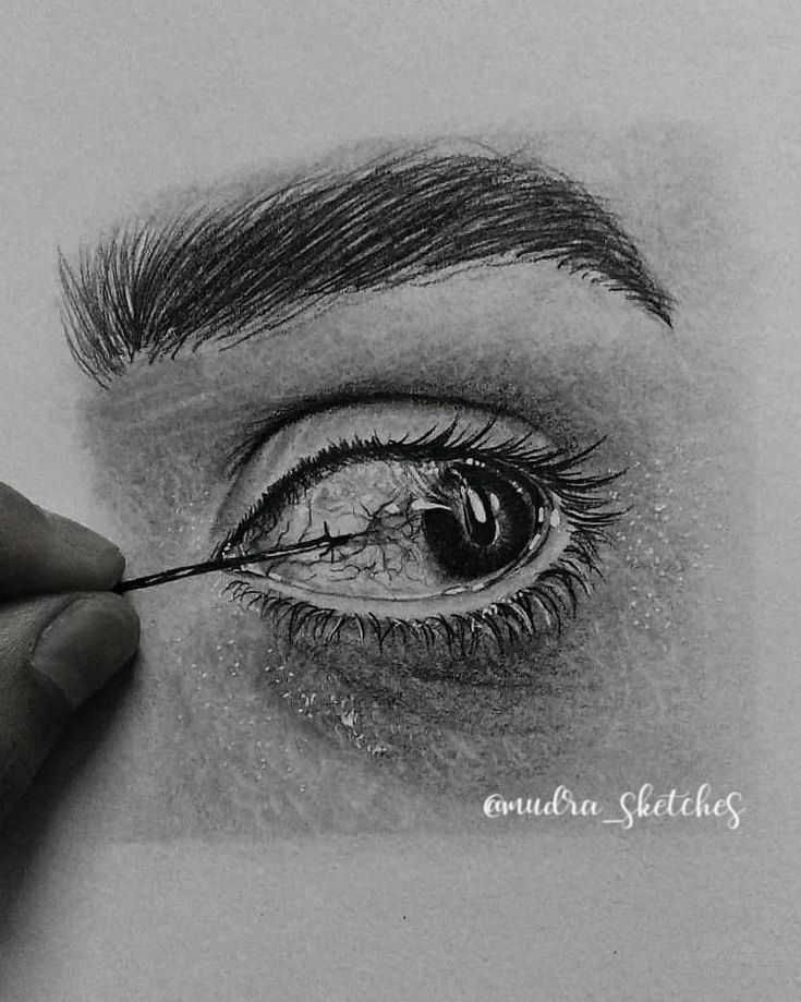 someone is drawing an eye with pencil