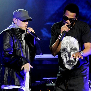 This may contain: two men standing next to each other on stage with microphones in their hands and one holding a skull mask