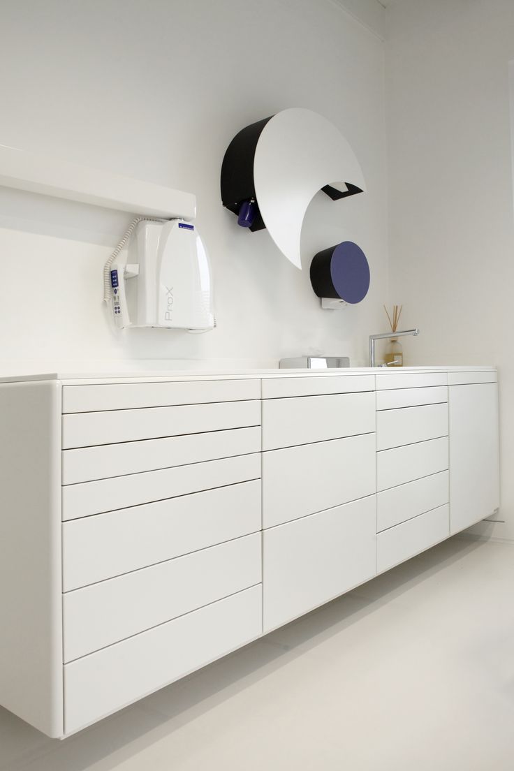 a white cabinet with two circular mirrors above it