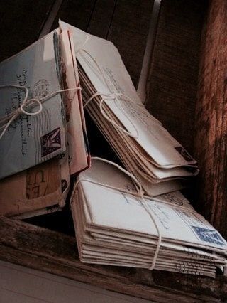 This may contain: several envelopes tied together in a wooden box