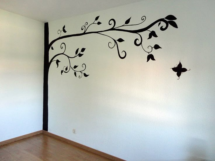 an empty room with a tree painted on the wall and birds flying in the air