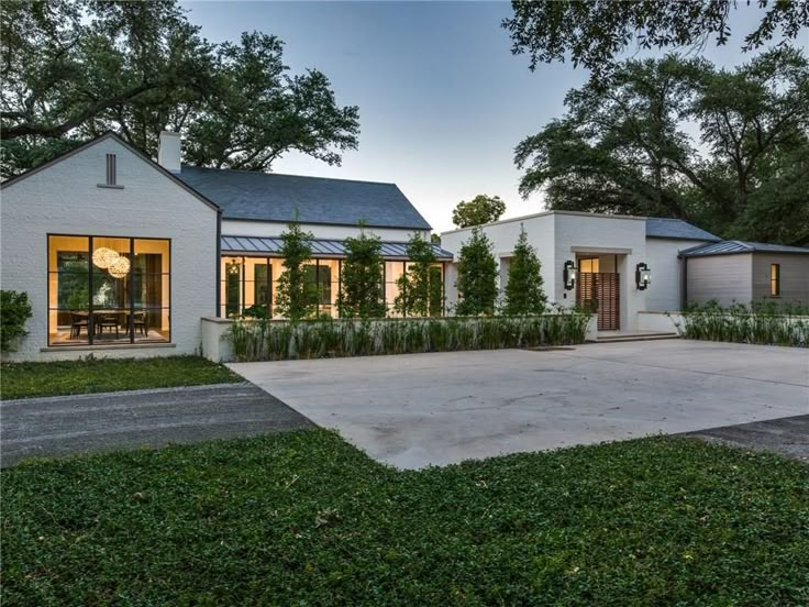 a white house sitting on top of a lush green field