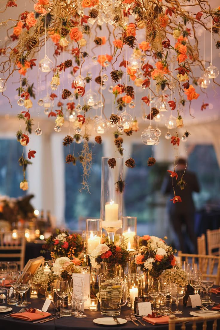 an elegant centerpiece with flowers and candles is displayed in the middle of a dining room