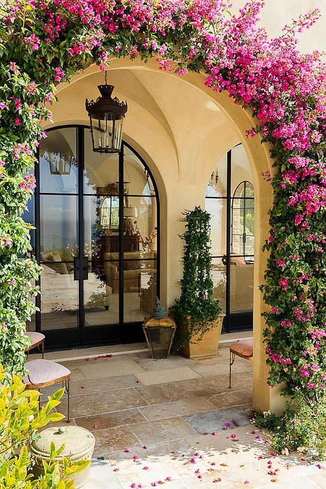 Arched entryway covered in greenery epitomizes the Mediterranean style  entry - Decoist | Spanish style homes, House exterior, Tuscan house